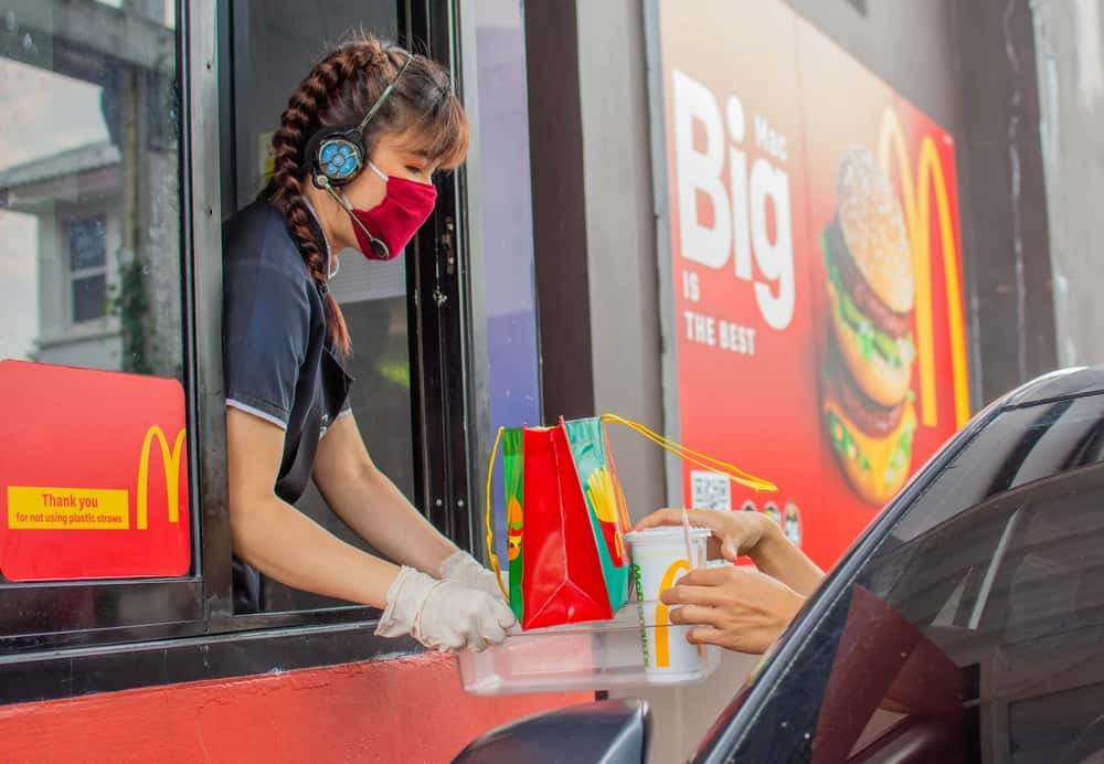 Female staff at McDonald's delivers food to customers