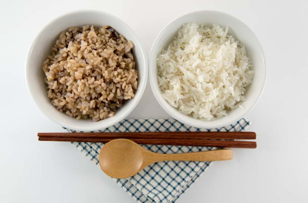 Cooked brown and white rice on white background