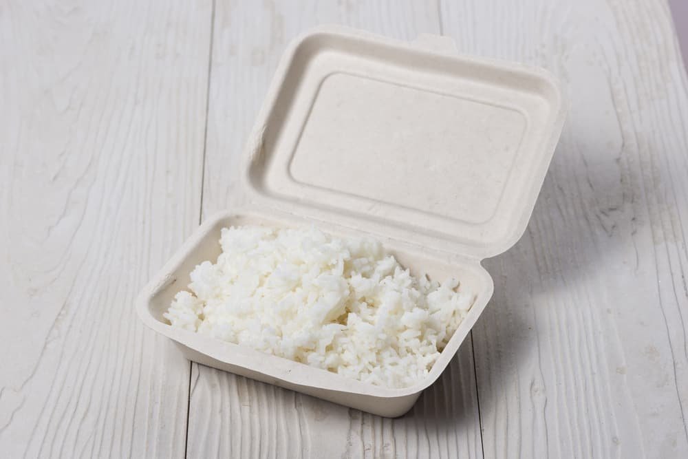 Take away rice in a paper box on wooden table